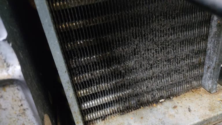 Condensador con polvo acumulado antes del mantenimiento preventivo
